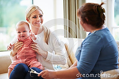 Health Visitor Talking To Mother With Young Baby Stock Photo