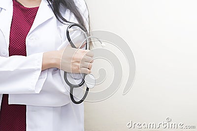 Healthcare background concept. Closeup doctor holding stethoscope standing on white wall with empty space. Stock Photo