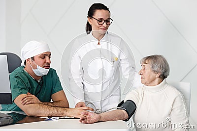 Healthcare in hospital. male surgeon and female doctor or nurse consulting senior lady patient in medical clinic cabinet Stock Photo