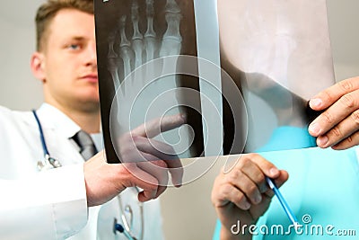 Healthcare, medical and radiology concept - Male doctors looking at x-ray of foot Stock Photo