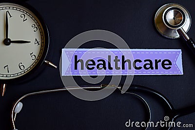 Healthcare on the print paper with Healthcare Concept Inspiration. alarm clock, Black stethoscope. Stock Photo