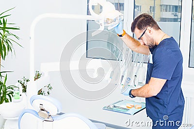 Healthcare, profession, stomatology and medicine concept - male dentist over medical office background Stock Photo