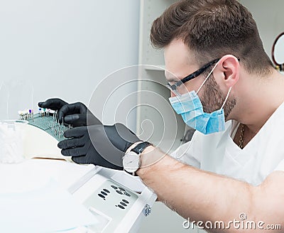 Healthcare, profession, stomatology and medicine concept - smiling male young dentist over medical office background Stock Photo