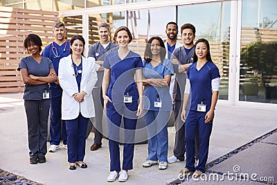 Healthcare team with ID badges stand outdoors, full length Stock Photo