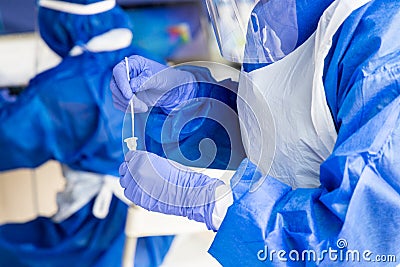 Healthcare worker mixing covid swab taken from patient into culture in extraction kit Stock Photo