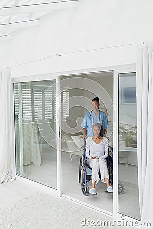 Healthcare worker and woman on a wheelchair Stock Photo