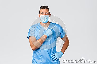Healthcare workers, covid-19, coronavirus and preventing virus concept. Surprised enthusiastic male nurse, doctor in Stock Photo