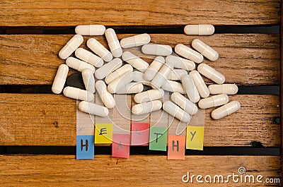 Healthy alphabet and capsule drug on wood background Stock Photo