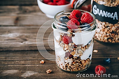Healthy blueberry and raspberry parfait with greek yogurt in glass mason jar on wood background Stock Photo