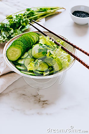 Healthy bowl, cucumber salad and coriander on marble background Stock Photo