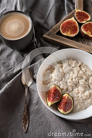 Healthy breakfast in bed. Coffee, porridge with figs, on a rustic wooden board. Clean food, alkaline diet, Stock Photo