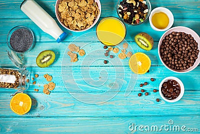 Healthy breakfast with bowl of cereal, orange juice, granola, milk, jam and fruits on blue wood background. Balanced diet. Stock Photo