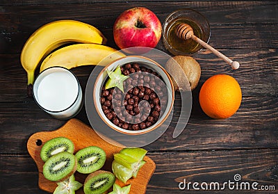 Healthy breakfast - cereal chocolate balls, milk and fruit on wood background Stock Photo