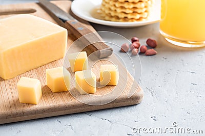 Healthy Breakfast Cheese on a Board cut into cubes Juice Peanuts waffle Cookies Selective focus. Stock Photo
