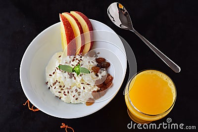 Healthy breakfast: cottage cheese with flax seeds, raisins, fresh apples and a glass of fresh orange juice. Healthy Stock Photo