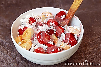 Healthy breakfast, cottage cheese with fruit strawberry and banana with wooden spoon. Organic natural diet concept. Stock Photo