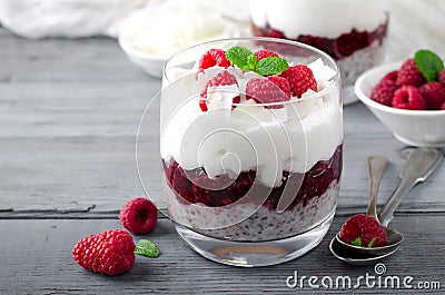 Healthy breakfast, desert, with chia seed pudding, cream, raspberry jam, coconut flakes and fresh berries Stock Photo