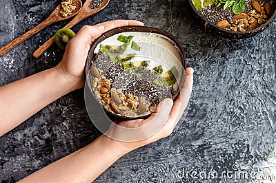 Healthy breakfast of fruit in a bowl of coconut, the girl holds in the palm, bali bowls, indonesia bali Stock Photo