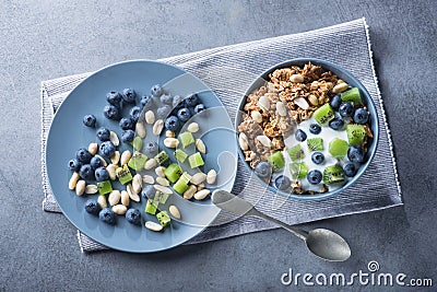 Healthy breakfast with granola cereal with blueberry, kiwi, yogurt and peanuts Stock Photo