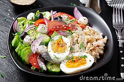 Greek inspired savory oatmeal with fresh cucumber, tomatoes, olives, lettuce, mozzarella cheese and boiled egg Stock Photo