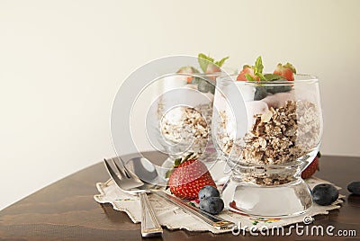 Healthy breakfast, oat meal with fruits: bluebery, strawbery and min, parfait in two glasses on a rustic background. Healthy food. Stock Photo