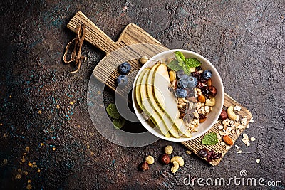 Healthy breakfast of oatmeal with fresh pear berry nuts and mint Stock Photo