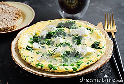 Healthy breakfast. Omelet with green peas, feta cheese and dill. Stock Photo