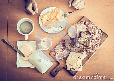 Healthy breakfast, scrambled eggs, black coffee, sandwiches with salami cheese , on a wooden table, top view Stock Photo