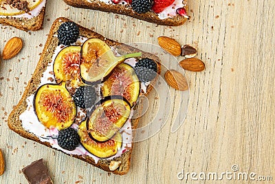 Healthy breakfast. Slice of wholegrain toast with cream cheese, figs, nuts and BlackBerry. Top view Stock Photo