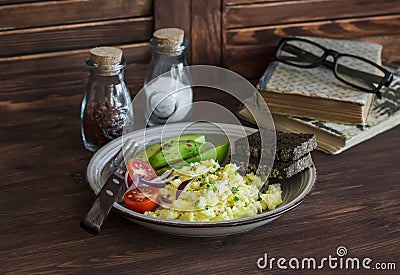 Healthy breakfast or snack - eggs scramble, avocado and cherry tomatoes Stock Photo