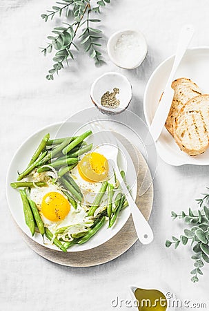 Healthy breakfast or snack - a fried egg with green beans on a light background Stock Photo