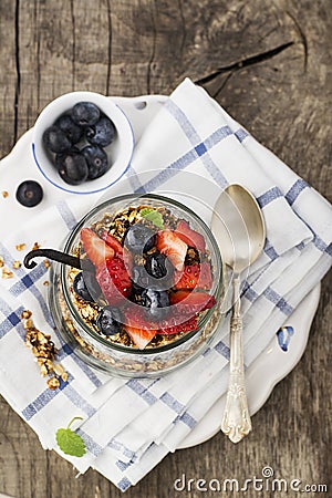 A healthy breakfast snack from granola, vanilla chia pudding, strawberries, blueberries in a large serving glass on a Stock Photo