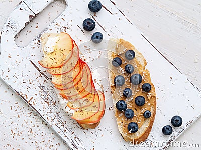 Healthy breakfast with sweet sandwiches - ricotta, blueberries, apple slices, peanut butter on white rustic wood table Stock Photo