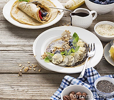 Healthy breakfast trend. Thin oat pancakes with banana, blueberries, goji berries, sesame and chia seeds Stock Photo