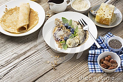 Healthy breakfast trend. Thin oat pancakes with banana, blueberries, goji berries, sesame and chia seeds Stock Photo