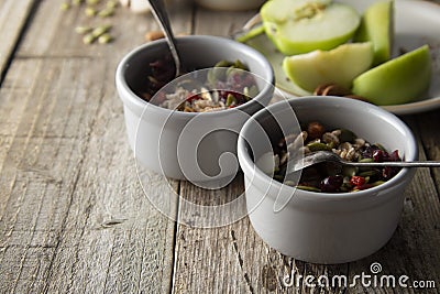 Healthy breakfast.Two bowls of muesli with oats, nuts and dried fruits - apples, resins, pumpkin seeds and almonds on wooden table Stock Photo