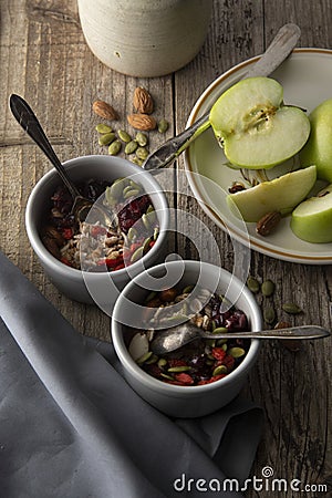 Healthy breakfast.Two bowls of muesli with oats, nuts and dried fruits - apples, resins, pumpkin seeds and almonds on wooden table Stock Photo