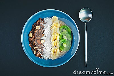 Healthy breakfast in vegan cafe.Whole grain oats porridge,rice & fruits in bowl Stock Photo