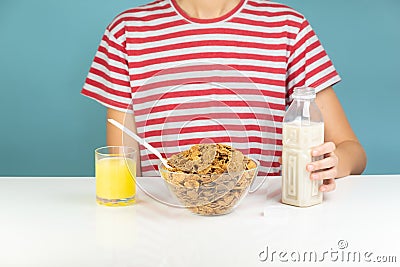 Healthy breakfast with whole grain cereals, milk and juice. Illustrative minimalistic image of vegetarian food on the table and h Stock Photo