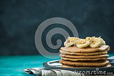 Healthy brunch, pancakes topped with banana and nuts Stock Photo