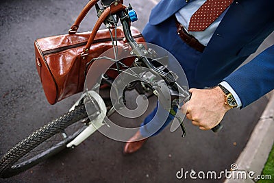Healthy businessman cycling with bag Stock Photo
