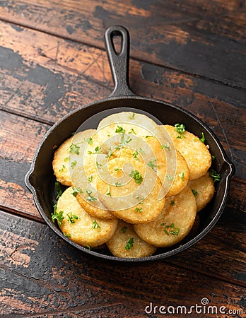 Healthy Cauliflower hash browns in cast iron frying pan on rustic wooden table Stock Photo