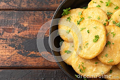 Healthy Cauliflower hash browns in cast iron frying pan on rustic wooden table Stock Photo