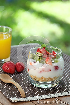 Healthy and colorful breakfast in the garden: Yoghurt with granola, strawberry and kiwi fruit Stock Photo