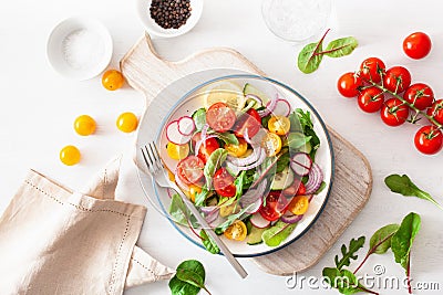 Healthy colorful vegan tomato salad with cucumber, radish, onion Stock Photo