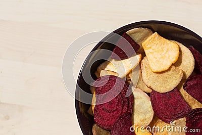 Healthy colorful vegetable chips in purple bowl. Stock Photo