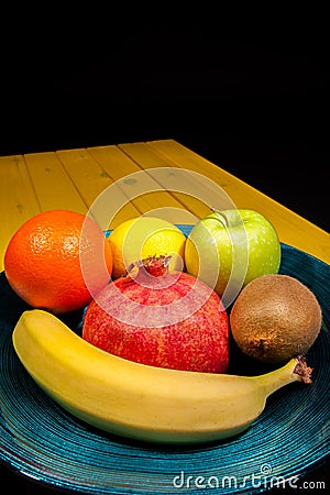 Healthy colourful fruit including pomegranate in decorative blue Stock Photo