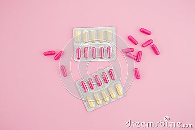 Healthy composition with vitamins pills on pink background. Flat lay, top view. Stock Photo