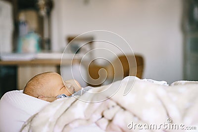 Healthy daytime sleep for the newborn. A baby in a baby cocoon sleeps in a room Stock Photo