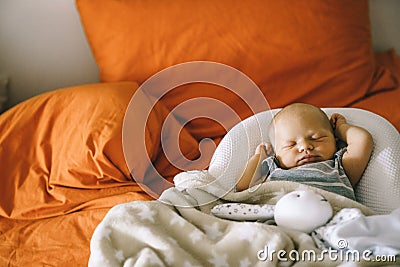 Healthy daytime sleep for the newborn. The baby is sleeping in the orthopedic Baby Cocoon on the bed Stock Photo